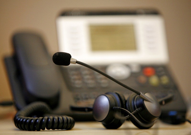 A headset is seen in front of a telephone in a call center in this Sept. 9, 2008 file photo. (AP/Miguel Villagran)