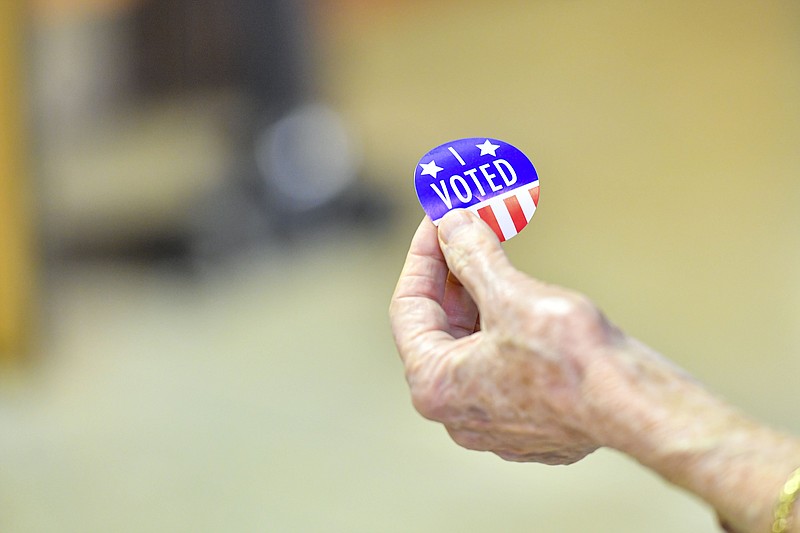 Jeanene Godwin, a poll worker, hands out an “I voted” sticker, Tuesday, March 5, 2024, at the Creekmore Park Recreation Building in Fort Smith. Visit rivervalleydemocratgazette.com/photo for today's photo gallery..(River Valley Democrat-Gazette/Hank Layton)