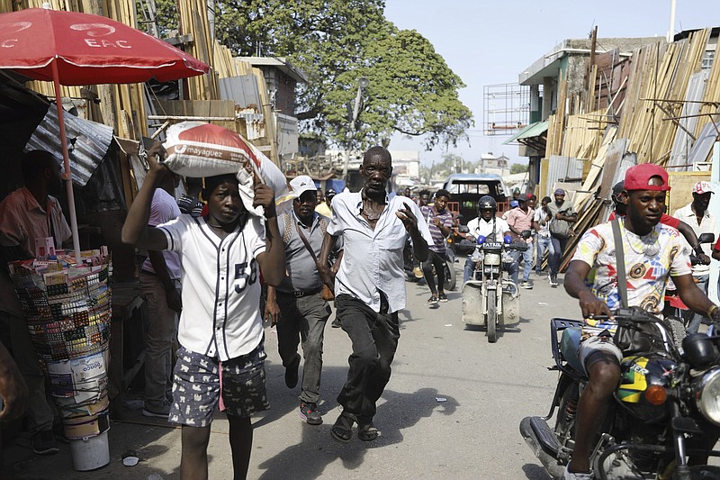 Pedestrians run for cover after hearing gunshots in Port-au- Prince, Haiti, on Thursday.
(AP/Odelyn Joseph)