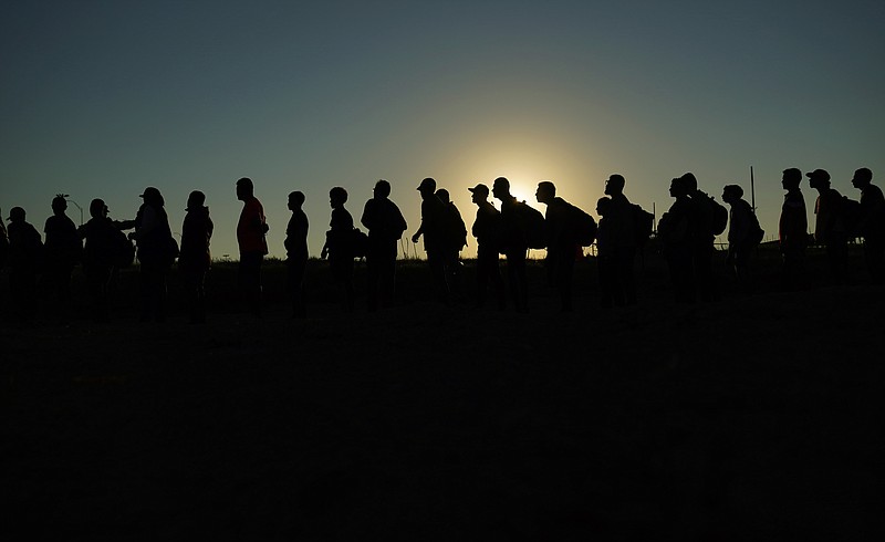 FILE - Migrants who crossed the Rio Grande and entered the U.S. from Mexico are lined up for processing by U.S. Customs and Border Protection, Saturday, Sept. 23, 2023, in Eagle Pass, Texas. A federal judge in Texas on Friday, March 8, 2024, upheld a key piece of President Joe Biden’s immigration policy that allows a limited number of migrants from four countries to enter the U.S. on humanitarian grounds, dismissing a challenge from Republican-led states that said the program created an economic burden on them. (AP Photo/Eric Gay, File)