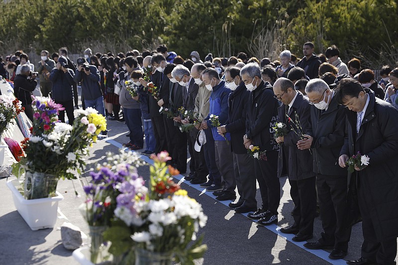 People observe a moment of silence at 2:46 p.m., the moment the earthquake struck in Iwaki, Fukushima prefecture, northern Japan Monday, March 11, 2024. Japan marked the 13th anniversary of the massive earthquake, tsunami and nuclear disaster. (Kyodo News via AP)