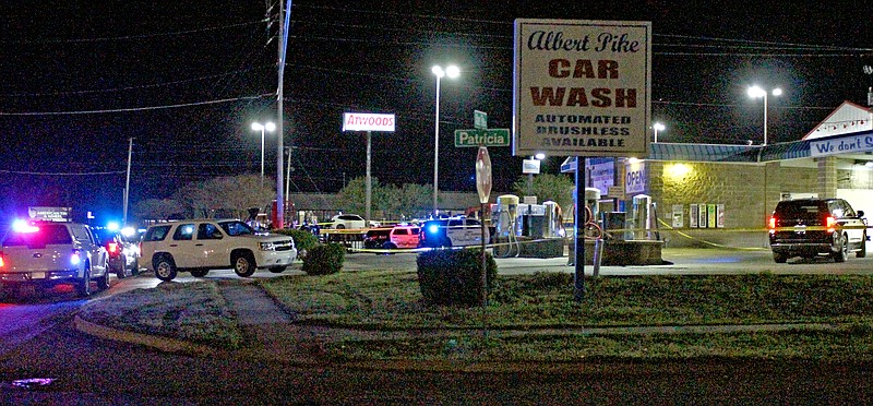 Law enforcement officials with the Hot Springs Police Department, Garland County Sheriff's Office and the Arkansas State Police investigate an officer-involved shooting that occurred during a traffic stop at Albert Pike Car Wash Monday night. (The Sentinel-Record/James Leigh)