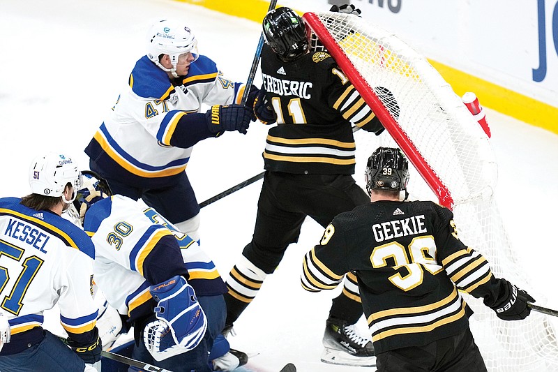 Bruins center Trent Frederic is checked by Blues defenseman Torey Krug during the first period of Monday night’s game in Boston. (Associated Press)