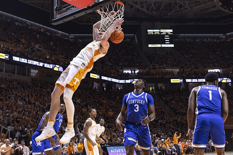 Tennessee guard Dalton Knecht, top left, dunks past Kentucky guard Adou Thiero, center,during the first half of an NCAA college basketball game Saturday, March 9, 2024, in Knoxville, Tenn. (AP Photo/Wade Payne)