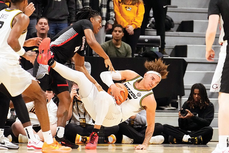 In this Jan. 6 file photo, Missouri’s Noah Carter falls after battling Georgia’s Silas Demary Jr. for the ball during a game at Mizzou Arena in Columbia. (Associated Press)