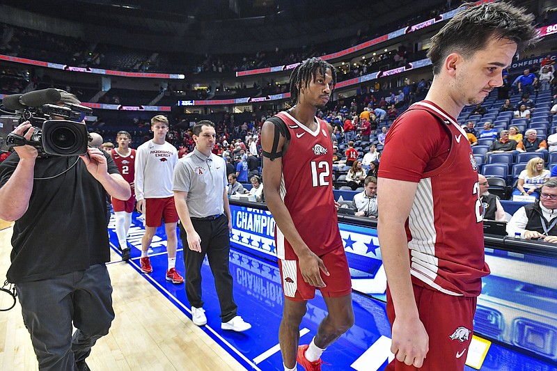 Arkansas guards Cade Arbogast (right), Tramon Mark (12) and other staff members and players walk off the court Thursday at Bridgestone Arena in Nashville, Tenn., after an 80-66 loss to No. 15 South Carolina in the second round of the SEC Tournament. More photos at nwaonline.com/315uasec24/.
(NWA Democrat-Gazette/Hank Layton)