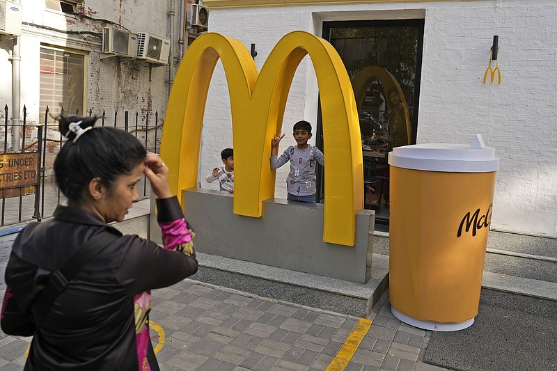 A woman takes a photograph of her children outside McDonald’s in New Delhi on Friday.
(AP/Manish Swarup)