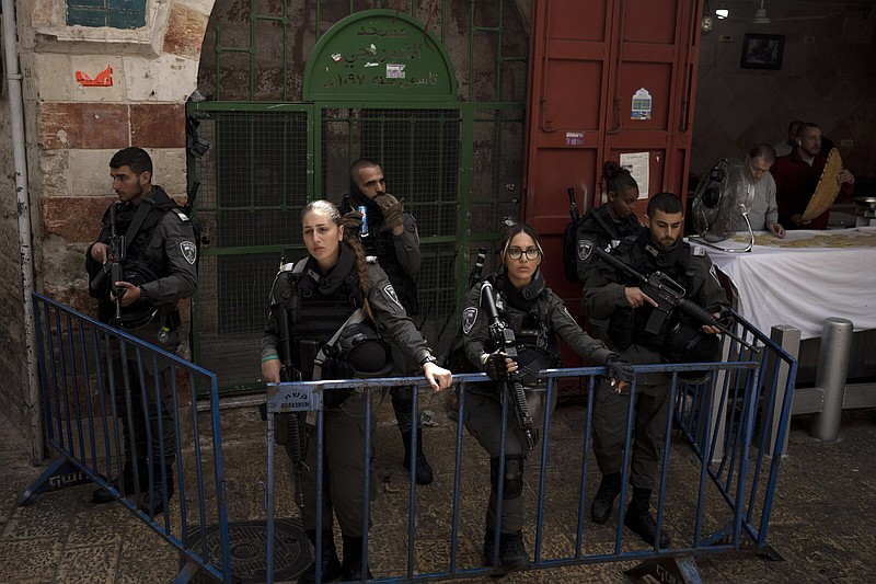 Israeli police watch Muslim worshippers in the Old City of Jerusalem make their way to the Al-Aqsa Mosque compound for the first Friday prayers of the Muslim holy month of Ramadan.
(AP/Maya Alleruzzo)
