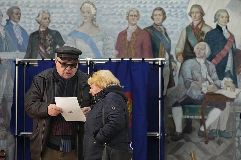 People examine a ballot at a polling station in a school during the presidential election in St. Petersburg, Russia, on Saturday.
(AP/Dmitri Lovetsky)