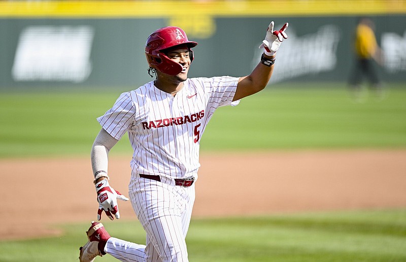 Arkansas right fielder Kendall Diggs gestures to his teammates as he runs toward home plate Saturday after his fifth home run of the season capped a six-run sixth inning for the top-ranked Razorbacks in a 6-0 victory over the Missouri Tigers in Fayetteville.
(NWA Democrat-Gazette/Charlie Kaijo)
