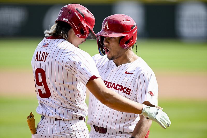 Arkansas infielder Wehiwa Aloy (9) scores on a home-run, Saturday, March 16, 2024 during the sixth inning of a baseball game at Baum-Walker Stadium in Fayetteville. Visit nwaonline.com/photos for today's photo gallery...(NWA Democrat-Gazette/Charlie Kaijo)