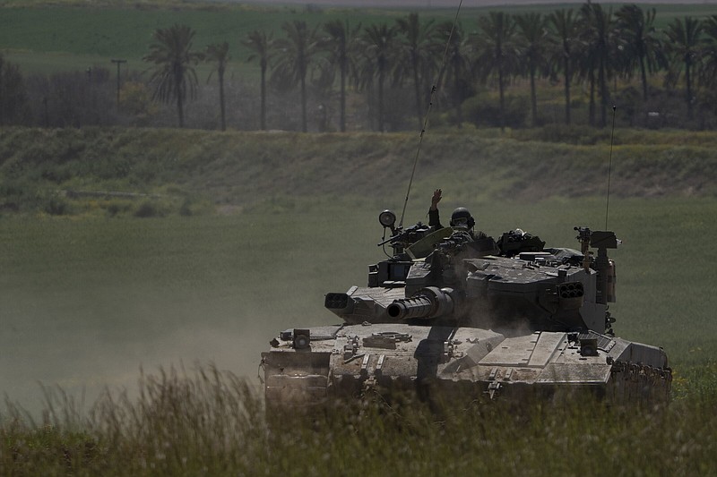 An Israeli soldier waves from the top of a tank near the Israeli-Gaza border, as seen from southern Israel on Wednesday. More photos at arkansasonline.com/gazaweek24/
(AP/Leo Correa)