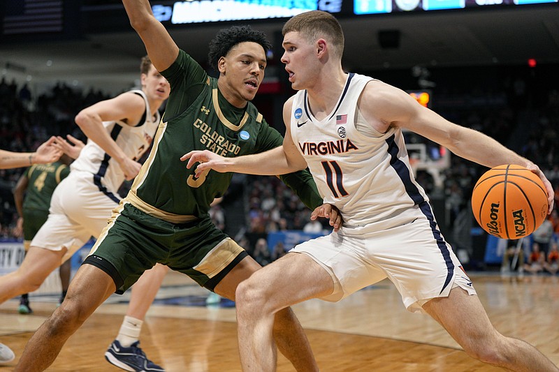 Virginia guard Isaac McKneely (11) controls the ball against Colorado State's Josiah Strong during the first half of a First Four college basketball game in the NCAA Tournament in Dayton, Ohio, Tuesday, March 19, 2024. (AP Photo/Jeff Dean)