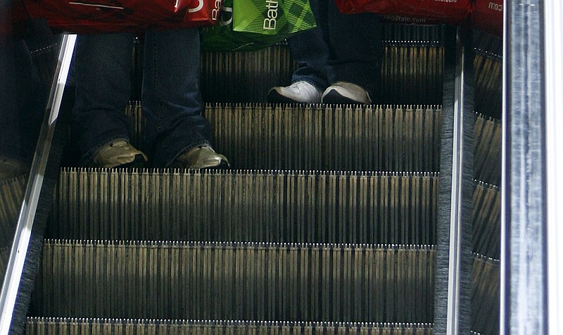 Shoppers' feet are visible as they ride down the escalator with their purchases at McCain Mall in North Little Rock in this November 2009 file photo. (Arkansas Democrat-Gazette file photo)