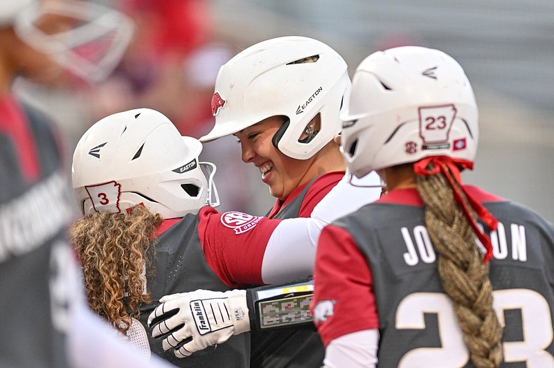 Arkansas third baseman Hannah Gammill (middle) celebrates with teammates Friday after hitting a three-run home run in the fourth inning of the No. 17 Razorbacks’ 6-3 loss to No. 20 Mississippi State at Bogle Park in Fayetteville. More photos at nwaonline.com/323msuua/.
(NWA Democrat-Gazette/Caleb Grieger)