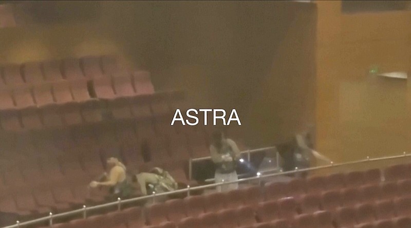 An image taken from video shows gunmen shooting in a concert hall in Krasnogorsk in the Moscow region area on Friday.
(AP/Astra)