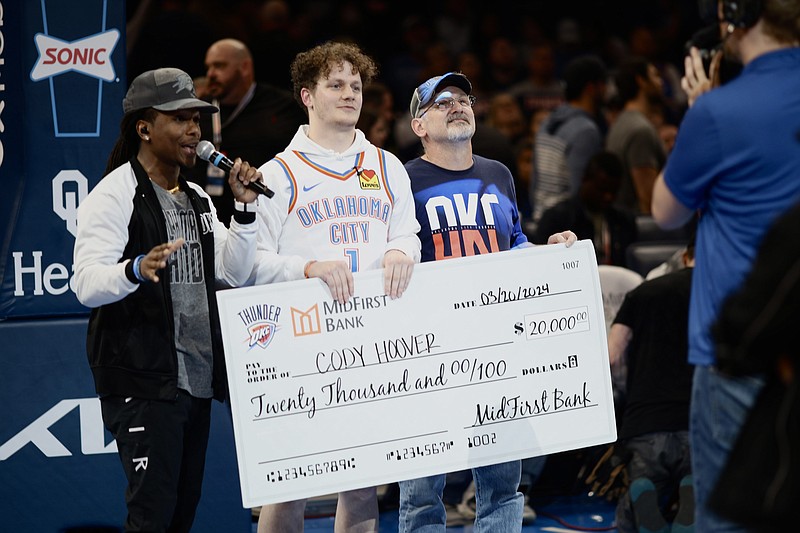 Cody Hoover holds the check for the $20,000 he won for making a half-court shot during a timeout at the Oklahoma City Thunder game in the Paycom Center in Oklahoma City. From left to right are Malcolm Tubbs, OKC Thunder Emcee; Hoover; and Cody's father Joseph Hoover. (Photo courtesy of Oklahoma City Thunder).