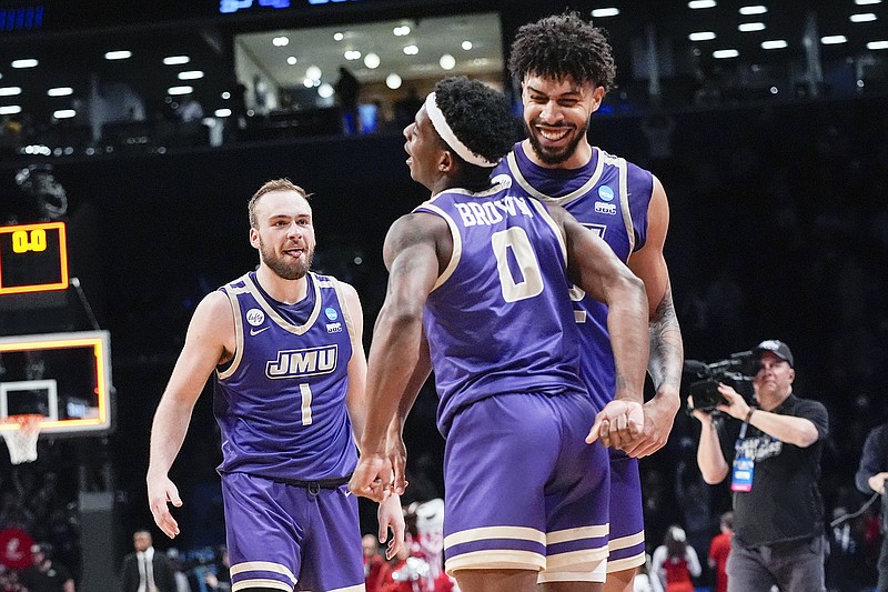 James Madison teammates (from left) Noah Freidel, Xavier Brown and Julien Wooden celebrate after a men's NCAA Tournament first-round win against Wisconsin in New York. (Associated Press)