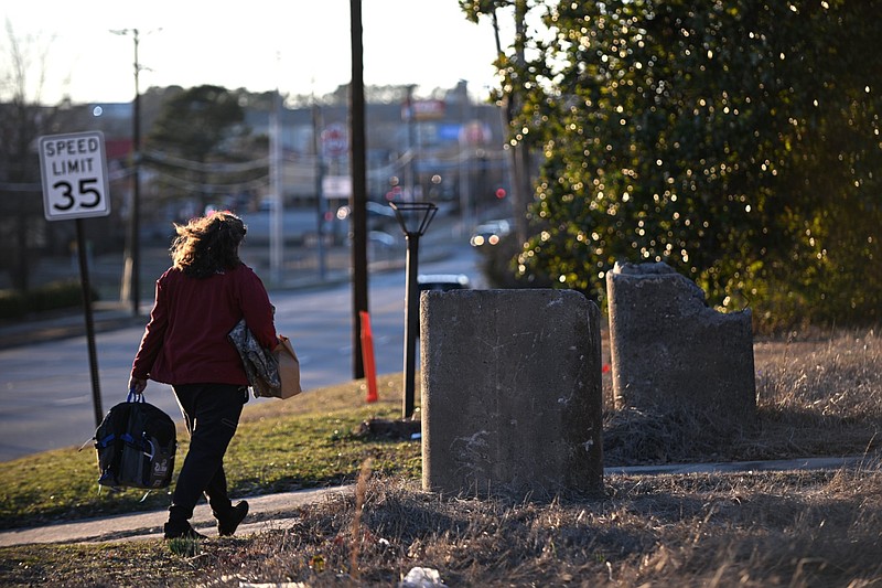 Aaron Reddin, founder of The Van, carries clothes and backpacks to a homeless man in North Little Rock in this Jan. 27, 2023 file photo. (Arkansas Democrat-Gazette/Staci Vandagriff)