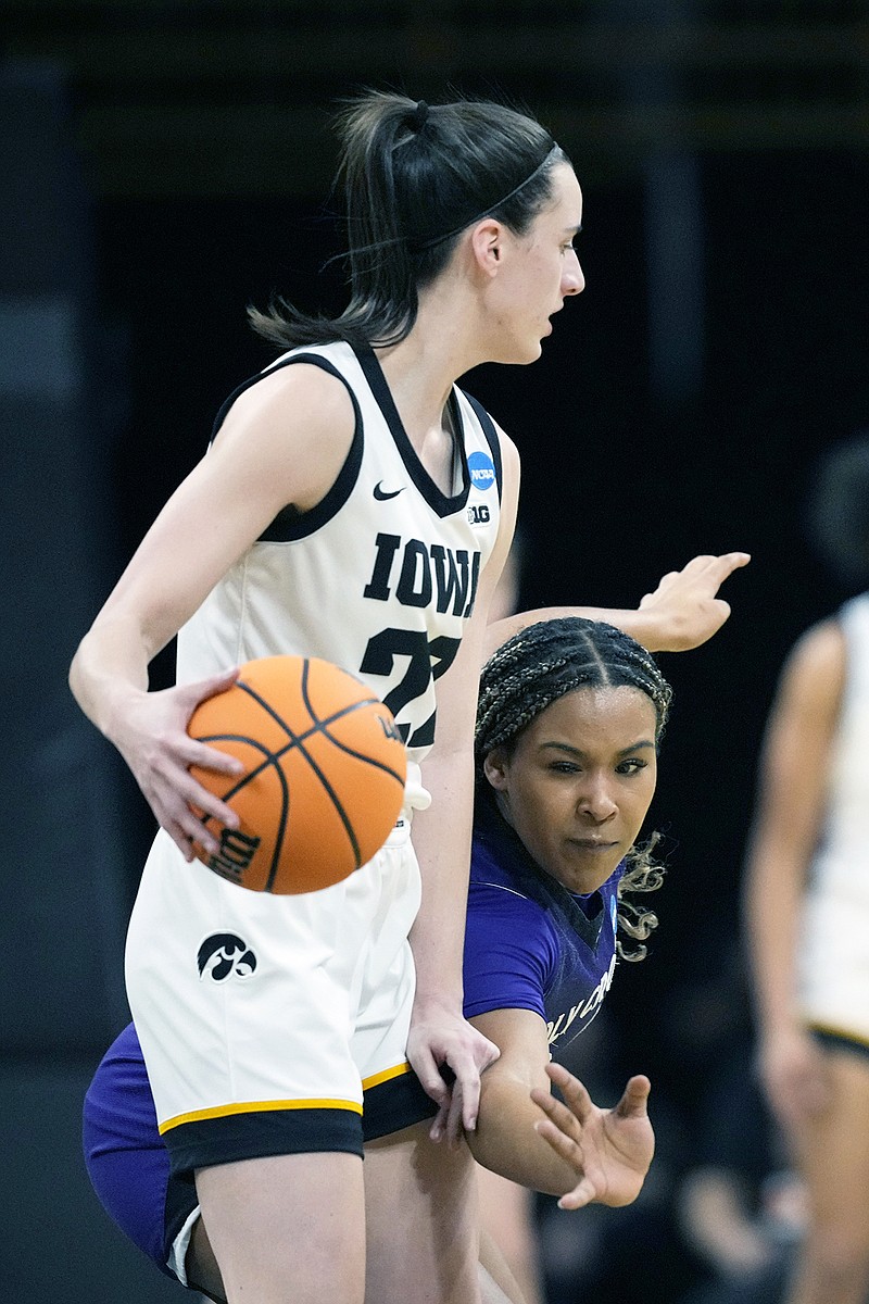 Holy Cross guard Simone Foreman tries to poke the ball free from Iowa guard Caitlin Clark during Saturday's first-round game in the NCAA Tournament in Iowa City, Iowa. (Associated Press)