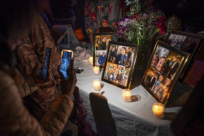People view photos on display during a vigil for Riley Strain, on Gay Street near the Cumberland River in Nashville, Tenn., Friday, March 22, 2024. The body of the missing University of Missouri student was discovered Friday morning in the Cumberland River. (Andrew Nelles/The Tennessean via AP)