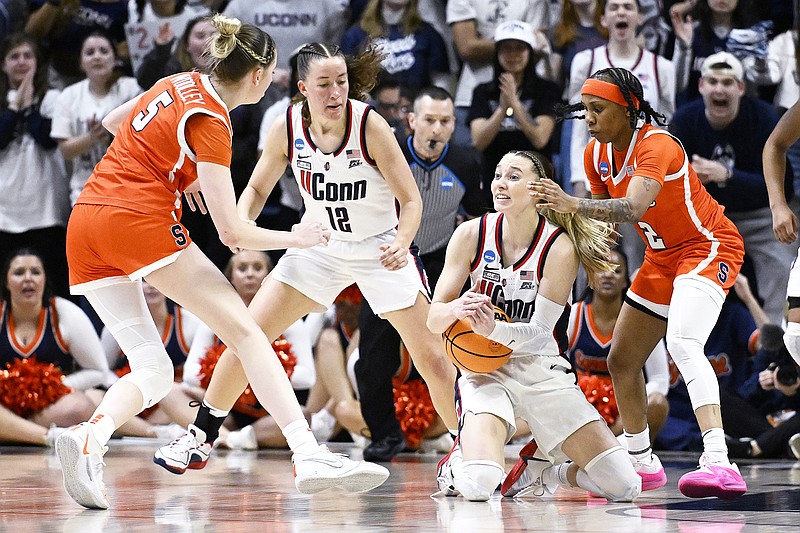 UConn guard Paige Bueckers gestures for a timeout while under pressure from Syracuse guards Georgia Woolley (left) and Dyaisha Fair as teammate Ashlynn Shade (12) looks on in the second half of Monday's second-round game in the women's NCAA Tournament in Storrs, Conn. (Associated Press)