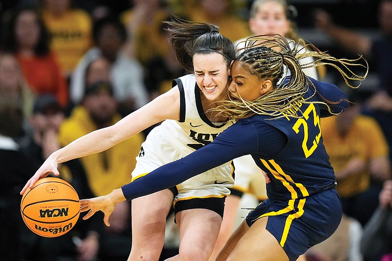 West Virginia guard Lauren Fields tries to steal the ball from Iowa guard Caitlin Clark in the first half of Monday night’s second-round game in the women's NCAA Tournament in Iowa City, Iowa. (Associated Press)
