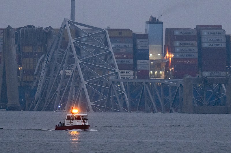 A container ship rests against wreckage of the Francis Scott Key Bridge near sunrise on Wednesday, March 27, 2024, in Baltimore, Md. Recovery efforts resumed Wednesday for the construction workers who are presumed dead after the cargo ship hit a pillar of the bridge, causing the structure to collapse. (AP Photo/Matt Rourke)