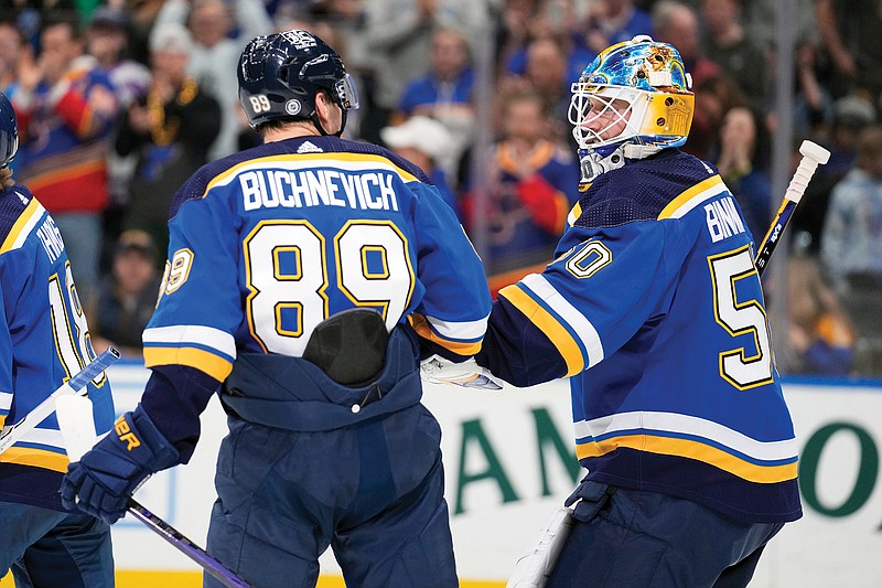 Pavel Buchnevich is congratulated by Blues teammate Jordan Binnington after scoring an empty-net goal late in the third period of Thursday night’s game against the Flames at Enterprise Center in St. Louis. (Associated Press)