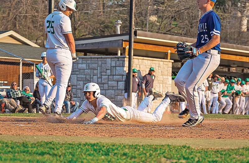 Evan McCullough of Blair Oaks slides into home plate between teammate Harrison Lear and Russellville pitcher Jack Lake during Thursday night’s game at Vivion Field. (Garrett Bradley/News Tribune)
