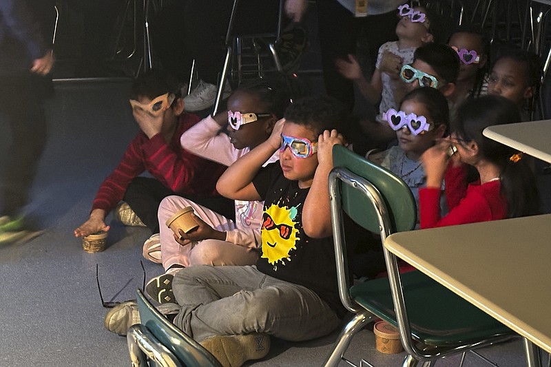 Second-grade student Jose Byrd (black T-shirt with sun) and classmates try out eclipse viewing glasses that they decorated at Riverside Elementary School in Cleveland in this March 14, 2024 file photo. Teachers in or near the path of totality say they have worked to come up with educational and engaging lessons for the rare event. (AP/Carolyn Thompson)