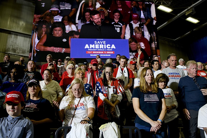FILE — Supporters pray during a campaign rallly for former President Donald Trump in Warren, Mich., on Oct. 1, 2022. Even more than in his past campaigns, Trump is framing his 2024 bid for the presidency as a fight for Christianity. (Brittany Greeson/The New York Times)