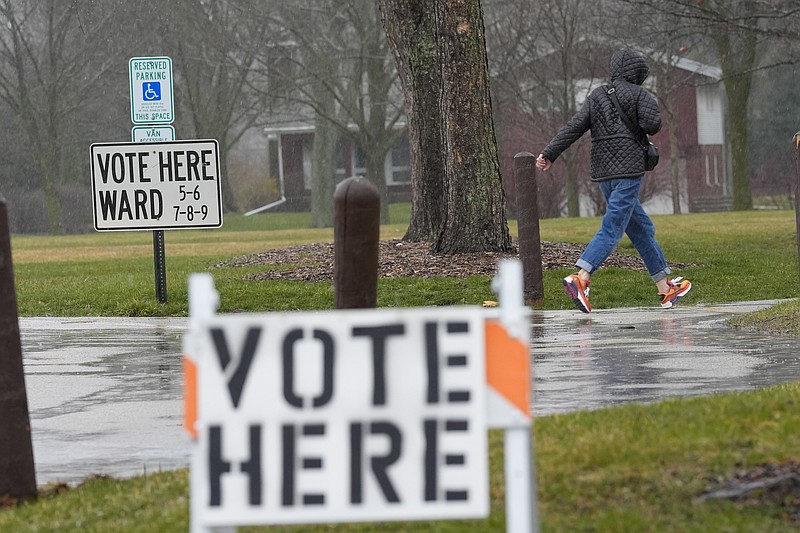 A voter braves a cold rain running to cast a ballot during the Spring election Tuesday, April 2, 2024, in Fox Point, Wis. (AP Photo/Morry Gash)