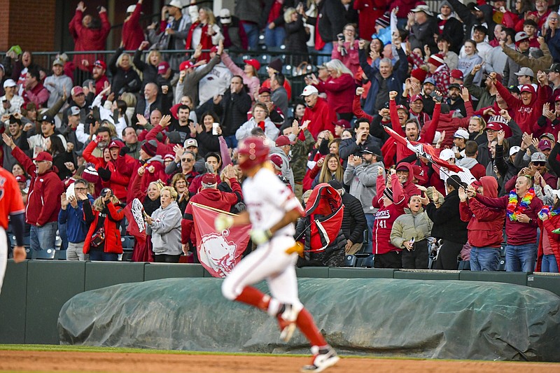 Arkansas fans cheer Thursday as shortstop Wehiwa Aloy rounds first base after hitting a go-ahead three-run home run during the sixth inning of the top-ranked Razorbacks’ 5-2 victory over the Ole Miss Rebels at Baum-Walker Stadium in Fayetteville. More photos at nwaonline.com/45umua/.
(NWA Democrat-Gazette/Hank Layton)