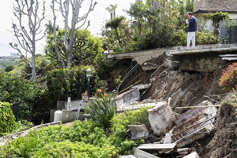 Homeowner Steven Peisner surveys the damage Thursday as he stands on his patio after an early morning landslide along the 1400 block of Galaxy Drive in Newport Beach, Calif.
(AP/The Orange County Register/Paul Bersebach)