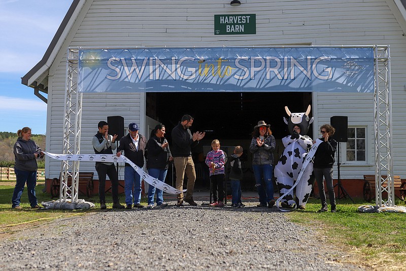 Staff photo by Olivia Ross / People cheer as the ribbon is cut. The grand opening of a passive park at McDonald Farm was held during the Swing into Spring event on Saturday, April 6, 2024. The event featured a ribbon cutting, live music, vendors, food and more.