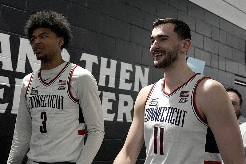 UConn forward Alex Karaban (11) and forward Jaylin Stewart exit the interview room ahead of a Final Four college basketball game in the NCAA Tournament, Thursday, April 4, 2024, in Glendale, Ariz. UConn will face Alabama on Saturday. (AP Photo/Brynn Anderson )