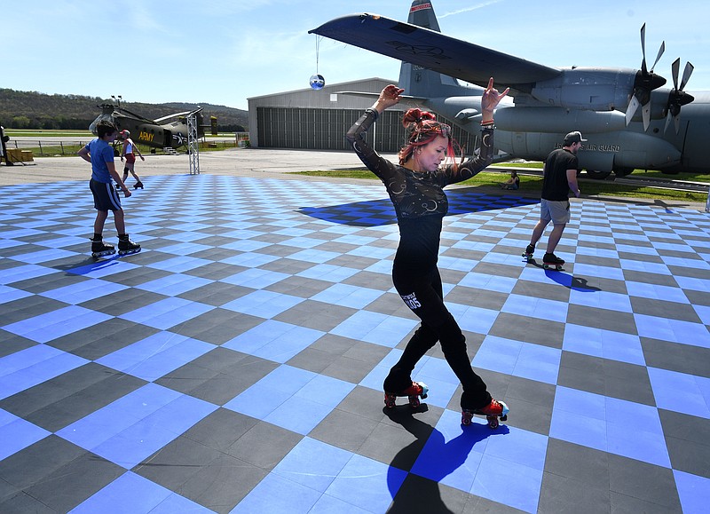 Tina 'Catwolf' McDonald dances Monday, April 8, 2024, while watching the solar eclipse and roller skating at the Arkansas Air and Military Museum in Fayetteville. The museum partnered with Starlight Skatium which debuted its new mobile skating rink for the free event. Visit nwaonline.com/photo for today's photo gallery..(NWA Democrat-Gazette/Andy Shupe)