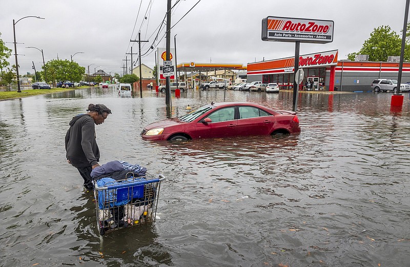 People carry their belongings down a flooded Broad Street in New Orleans during a severe rainstorm on Wednesday.
(AP/The Times-Picayune/The New Orleans Advocate/Chris Granger)