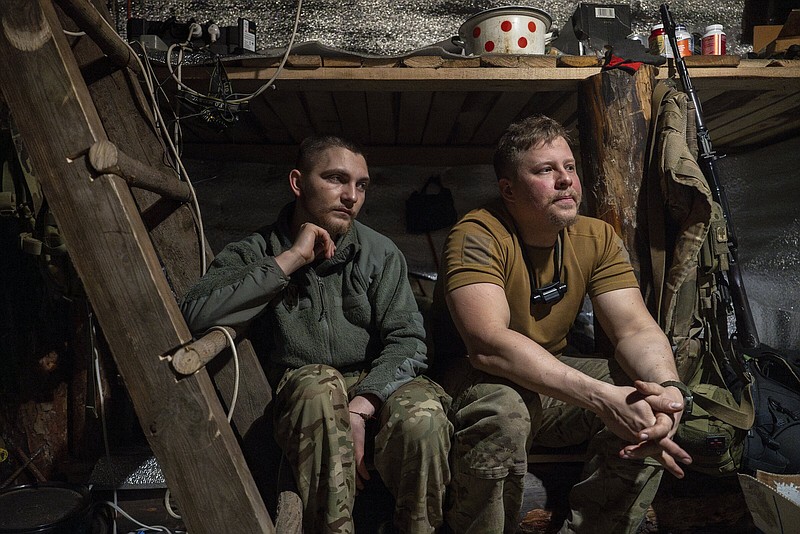 Ukrainian servicemen from the Azov brigade known by call signs Ray (left) and Kiss (right), rest in the trenches on the front line in Kreminna direction, Donetsk region, Ukraine, on Thursday.
(AP/Alex Babenko)