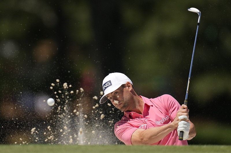 Taylor Moore blasts from a bunker on the seventh hole Friday during the second round of the Masters. The former University of Arkansas golfer finished with a 3-over 75 and sits at 2 over for the tournament heading into today’s third round.
(AP/Ashley Landis)