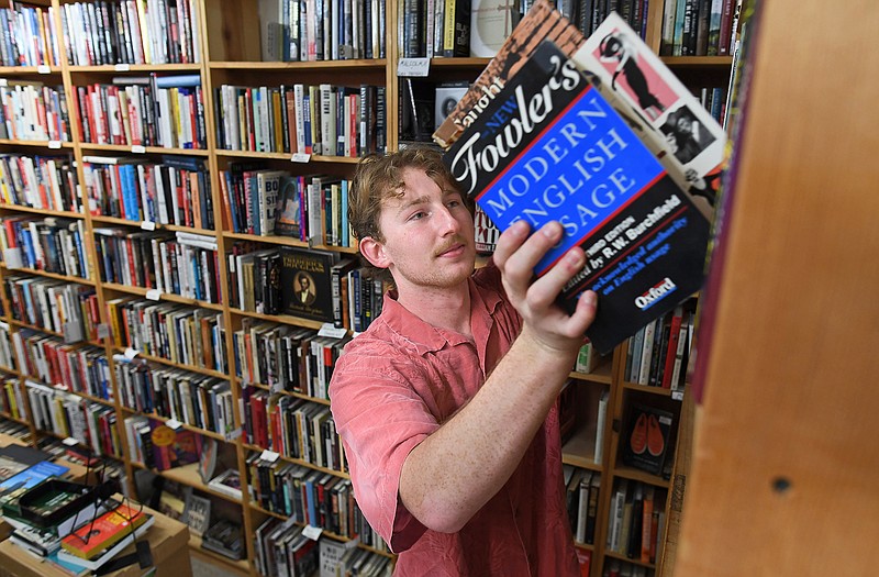 Employee Harrison Lowe shelves reference books at the Dickson Street Bookshop in Fayetteville on Friday.
(NWA Democrat-Gazette/Andy Shupe)