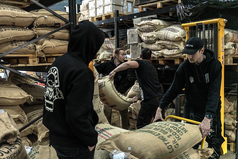 Workers move sacks of coffee beans at Mad Heads Coffee, a coffee roaster and shop in Kyiv, Ukraine, on March 14, 2024. At the start of the war, Mad Heads’ co-founder began receiving messages from Ukrainian soldiers asking for ground coffee and beans to bring to the front. (Brendan Hoffman/The New York Times)