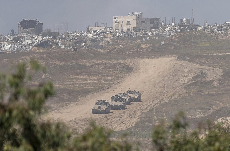Israeli armored personnel carriers move near the Israeli-Gaza border Wednesday, as seen from southern Israel.
(AP/Ohad Zwigenberg)