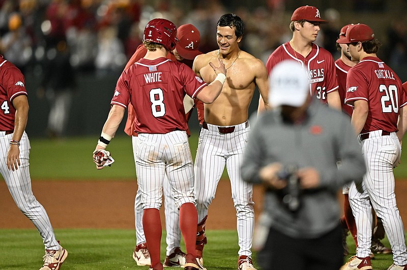 Arkansas players mob Nolan Souza after Souza's sacrifice fly to win the baseball game on Tuesday, April 16, 2024, at Baum-Walker Stadium in Fayetteville. The Arkansas Razorbacks hosted the Texas Tech Red Raiders in a non-conference matchup. Visit nwaonline.com/photo for today's photo gallery. (NWA Democrat Gazette/Caleb Grieger)
