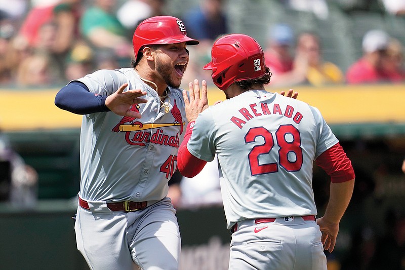 Cardinals teammates Willson Contreras and Nolan Arenado celebrate after they both scored on a single by Iván Herrera during the fourth inning of Wednesday afternoon’s game against the Athletics in Oakland, Calif. (Associated Press)