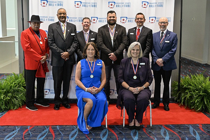 Members of the 2024 induction class of the Arkansas Sports Hall of Fame pose for a photo before Friday’s ceremony at the Statehouse Convention Center in Little Rock. Carla Crowder and Debbie Mallett, representing former Razorbacks quarterback Ryan Mallett, are seated in the front row. Back row, from left: Al Flanigan, Butch Gardner, Glen Day, Peyton Hillis, Jeff Glasbrenner and Erick Jackson. Inductees not pictured are Ed Harris and Jason Peters.
(Arkansas Democrat-Gazette/Staci Vandagriff)