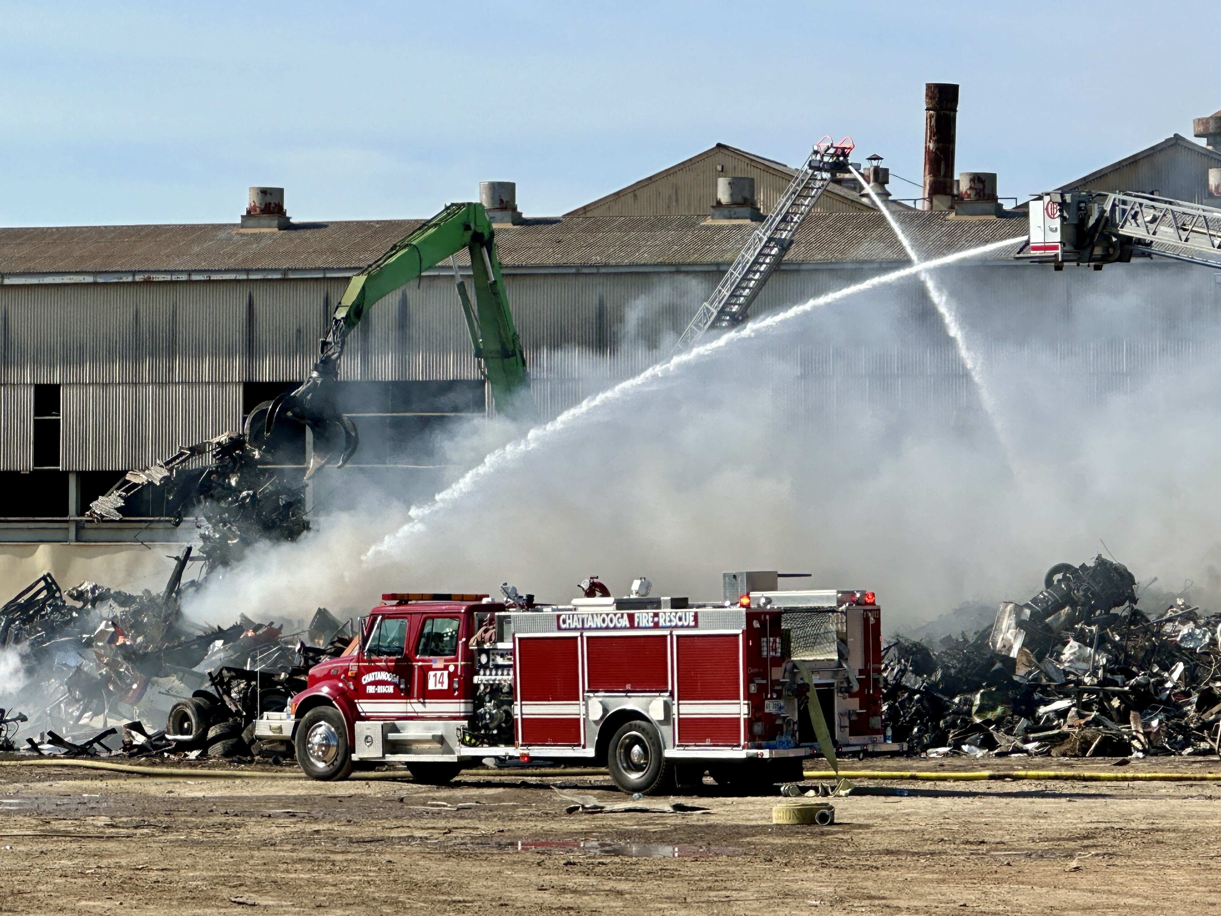 Chattanooga Fire Department / Fire crews work to put out a scrap metal fire near 980 West 19th Street are seen on Tuesday. Piles of scrap metal burned at the recycling facility, according to the Chattanooga Fire Department.