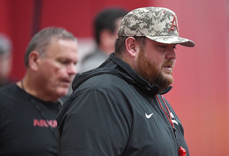 Arkansas offensive line coach Eric Mateos (front) directs his players while head coach Sam Pittman watches from behind during practice Thursday, March 7, 2024, in Fayetteville. (Andy Shupe/NWA Democrat-Gazette)