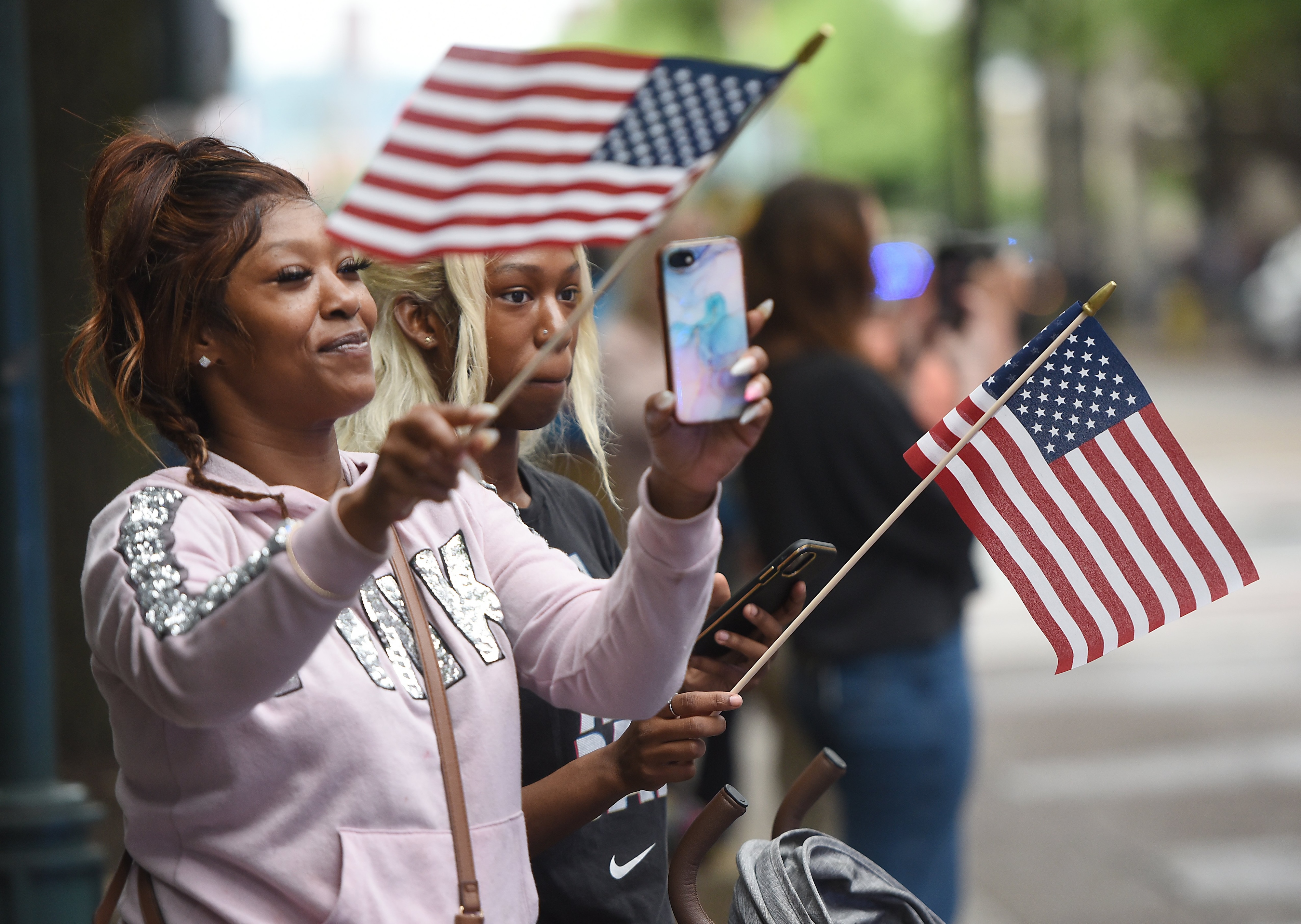 Staff photo by Matt Hamilton/ Kekee Cousin, front, and Prada Cousin wave American flags on Market Street during the 75th Armed Forces Day Parade on Friday, May 3, 2024.